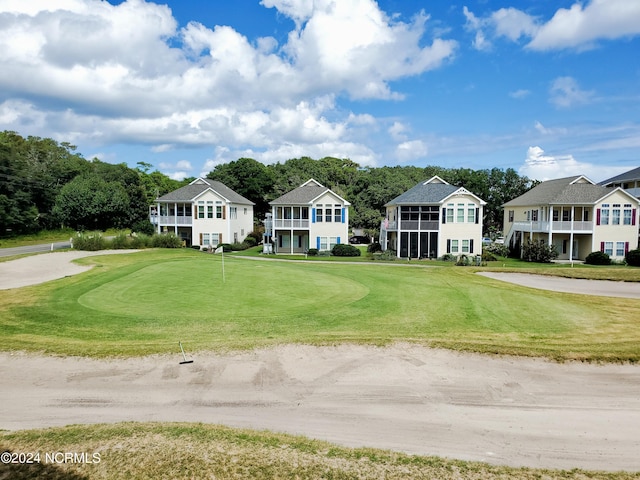 exterior space with view of golf course and a yard