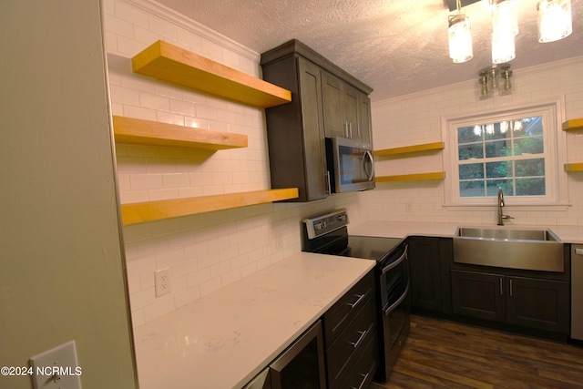 kitchen with dark hardwood / wood-style flooring, stainless steel appliances, a textured ceiling, ornamental molding, and sink