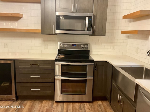 kitchen featuring appliances with stainless steel finishes, dark brown cabinetry, and light hardwood / wood-style floors