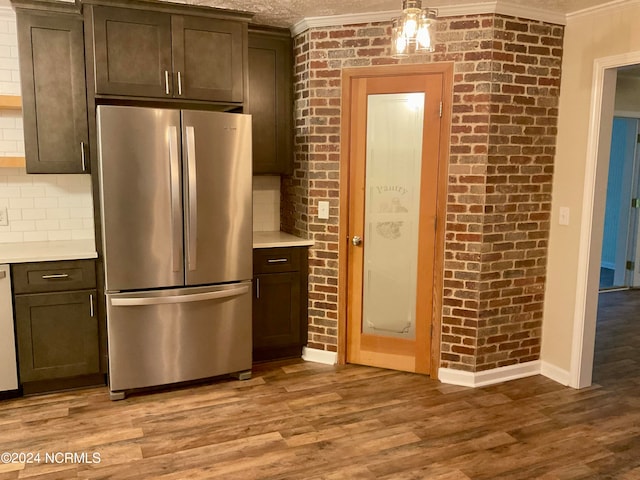 kitchen featuring dark brown cabinets, light hardwood / wood-style floors, and stainless steel fridge