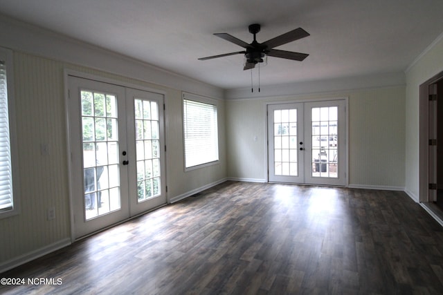 empty room with french doors, crown molding, dark wood-type flooring, and ceiling fan