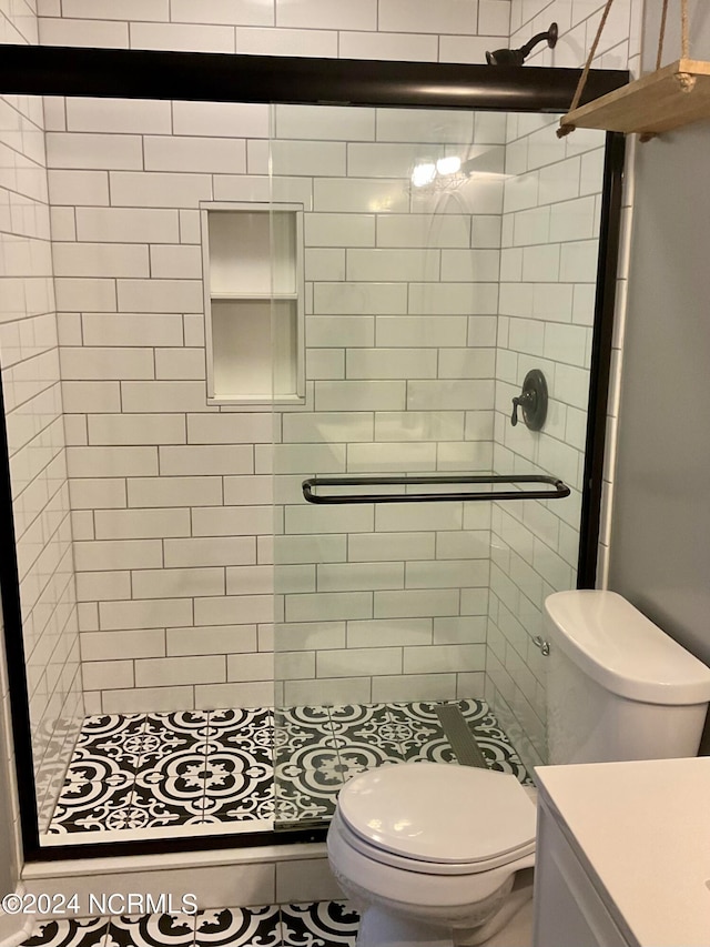 bathroom with walk in shower, vanity, and toilet