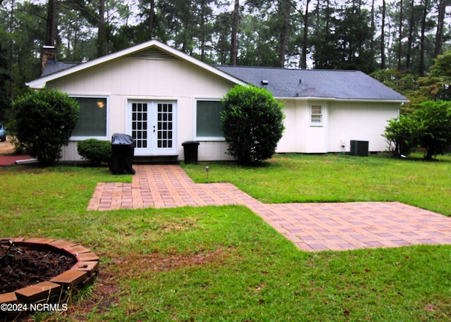 rear view of property featuring central AC unit, a yard, french doors, and a patio area