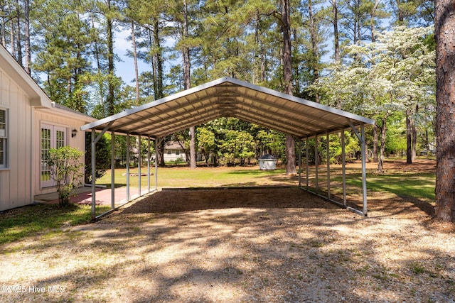 view of property's community featuring a detached carport, driveway, and a lawn