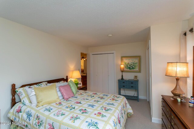 bedroom with light carpet, a closet, and a textured ceiling