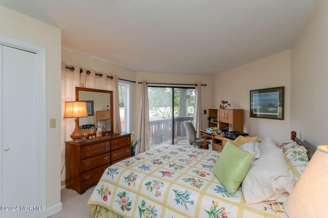 carpeted bedroom with a closet, a textured ceiling, and access to outside