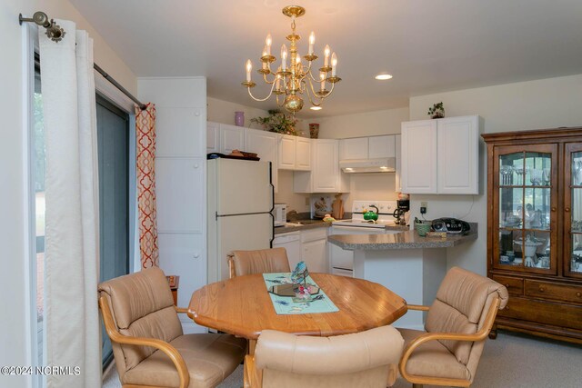 kitchen with an inviting chandelier, white appliances, white cabinetry, and hanging light fixtures