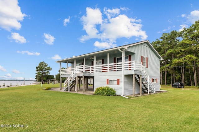 back of house with a yard, a patio area, and a water view