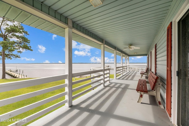 view of patio / terrace featuring ceiling fan, a water view, and a porch