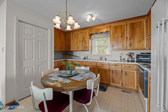 kitchen with pendant lighting, a notable chandelier, a textured ceiling, and white electric range oven