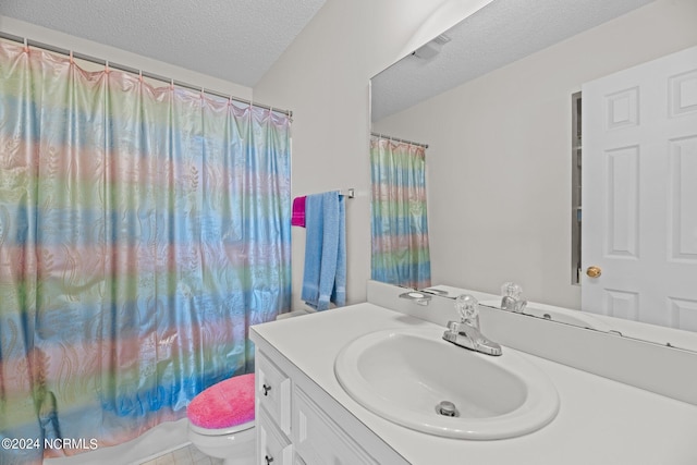 bathroom featuring vanity, toilet, and a textured ceiling