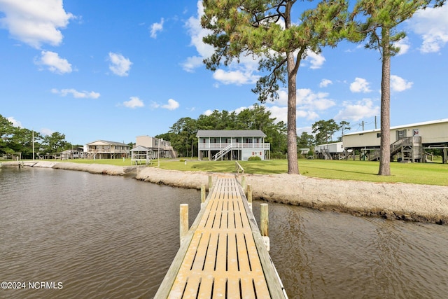 dock area with a lawn and a water view