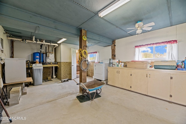 basement with a wealth of natural light, washing machine and dryer, a workshop area, and ceiling fan