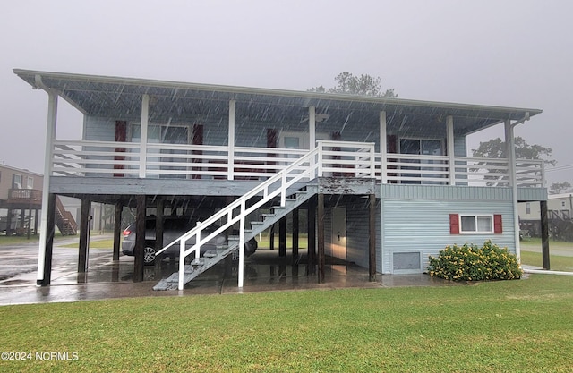 rear view of house featuring a lawn, a carport, and a deck