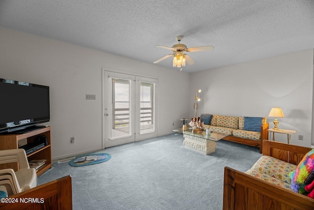 living room featuring a textured ceiling, ceiling fan, and carpet flooring