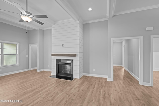 unfurnished living room featuring light wood-type flooring, ceiling fan, beam ceiling, and a fireplace