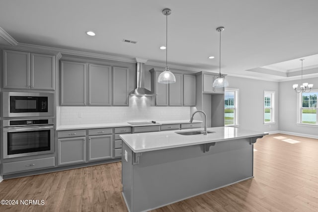 kitchen featuring wall chimney exhaust hood, sink, stainless steel oven, gray cabinetry, and built in microwave