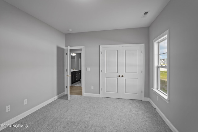 unfurnished bedroom featuring multiple windows, a closet, and carpet flooring