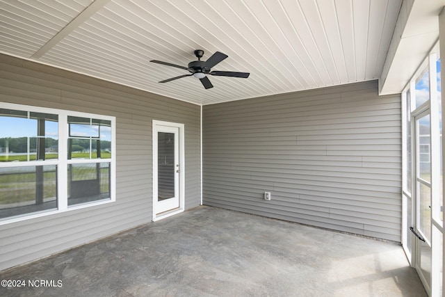 unfurnished sunroom featuring ceiling fan and plenty of natural light