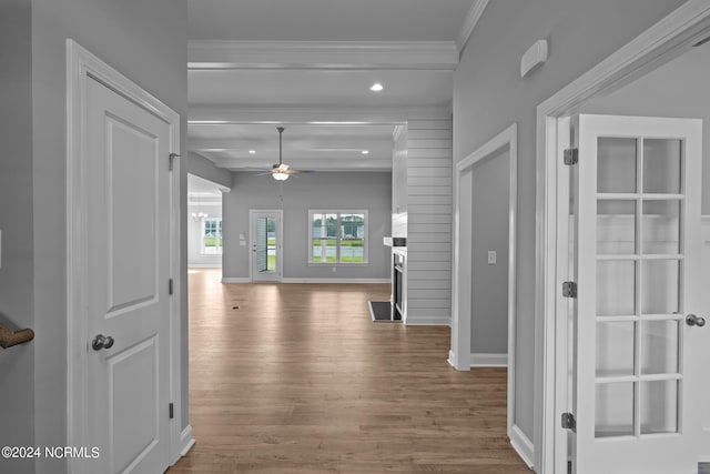 hall with ornamental molding, beam ceiling, and hardwood / wood-style floors