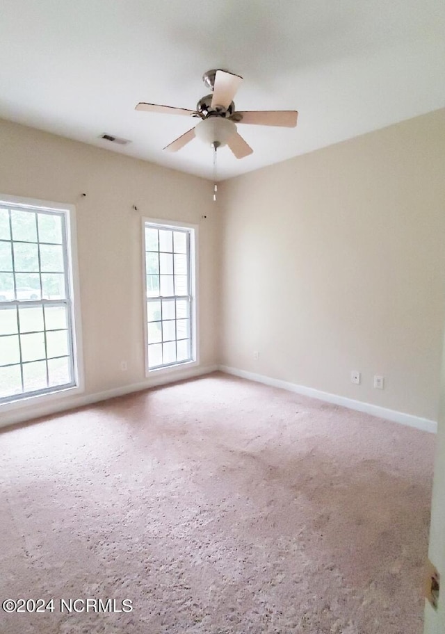 spare room featuring ceiling fan and carpet