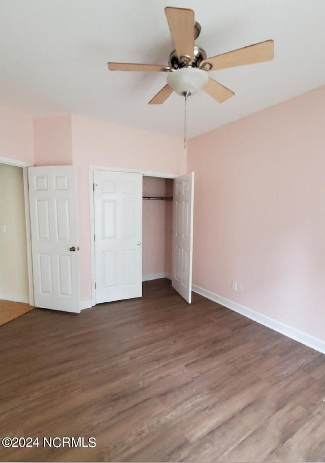 unfurnished bedroom featuring dark hardwood / wood-style flooring, ceiling fan, and a closet