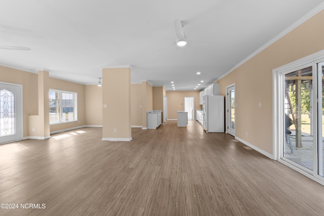 unfurnished living room with light hardwood / wood-style flooring, ceiling fan, and crown molding