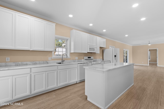 kitchen with sink, white cabinets, white appliances, and a kitchen island