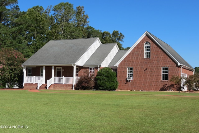 cape cod-style house featuring cooling unit, a front yard, and covered porch