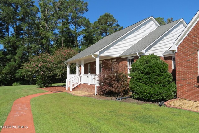 view of property exterior featuring a yard and covered porch