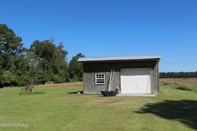 view of outdoor structure with a garage and a yard