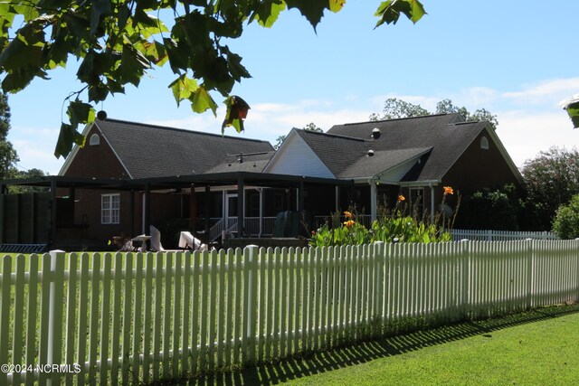 rear view of property with a sunroom and a yard