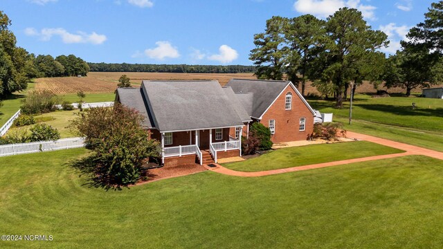 view of front of house with a front lawn, a rural view, and covered porch