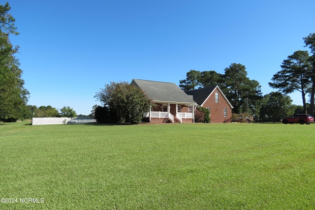 new england style home featuring a front lawn and covered porch