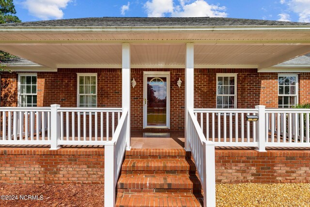 property entrance featuring a porch