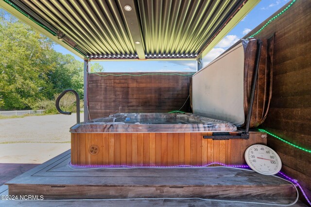 exterior space with a hot tub and concrete floors