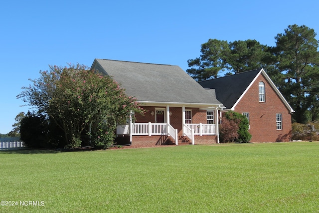 cape cod home with a front lawn and covered porch