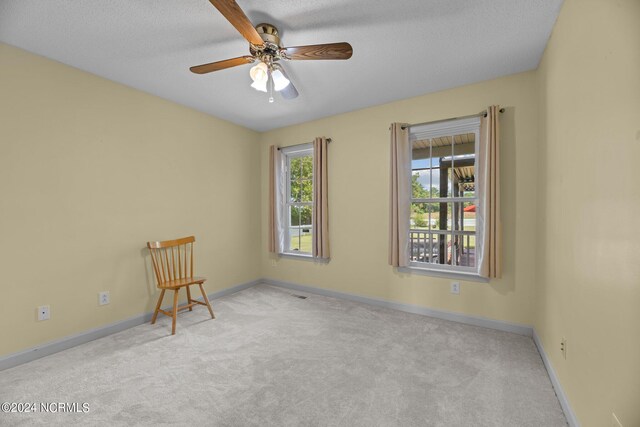 carpeted empty room with a textured ceiling and ceiling fan