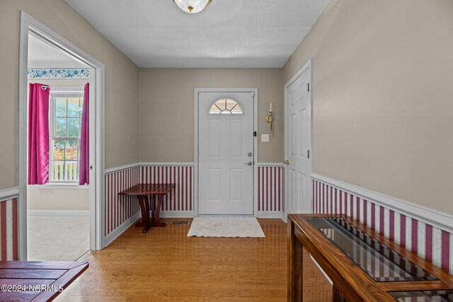 entryway featuring light wood-type flooring and a textured ceiling