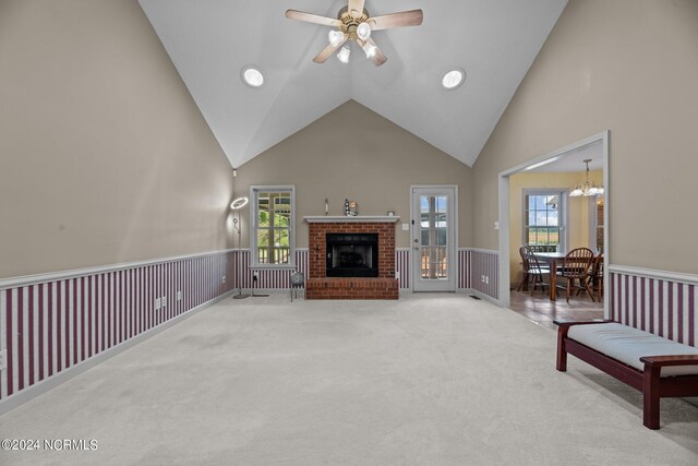 living room featuring high vaulted ceiling, a fireplace, ceiling fan, and a wealth of natural light