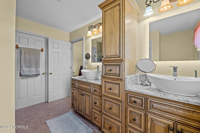 bathroom featuring a textured ceiling, tile patterned flooring, and vanity