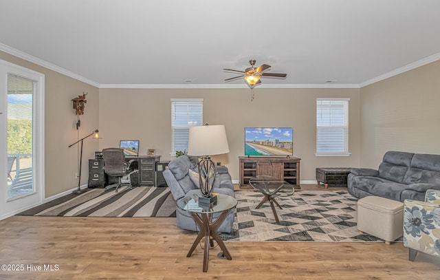 living room featuring a wealth of natural light, crown molding, and light hardwood / wood-style flooring