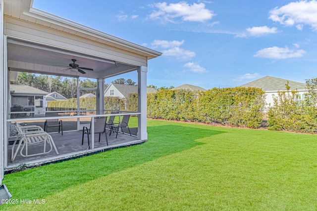 view of yard featuring ceiling fan and a sunroom