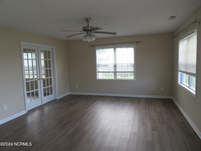 empty room with dark wood-type flooring, a healthy amount of sunlight, and ceiling fan