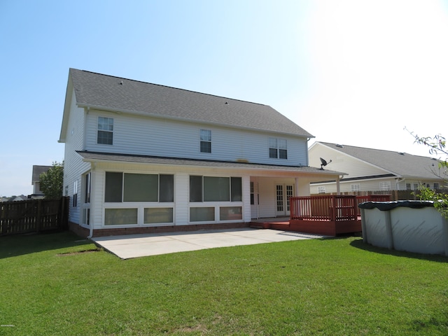 rear view of house with a wooden deck, a yard, and a patio area