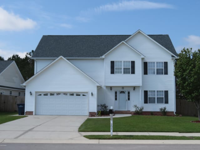 view of front of home featuring a garage and a front lawn