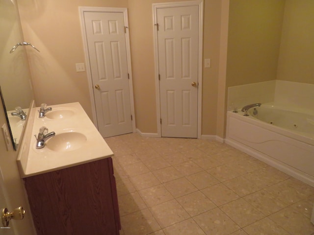 bathroom with tile patterned flooring, a bathtub, and vanity