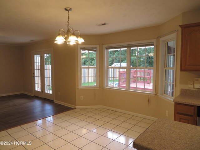 unfurnished dining area featuring an inviting chandelier and light hardwood / wood-style floors