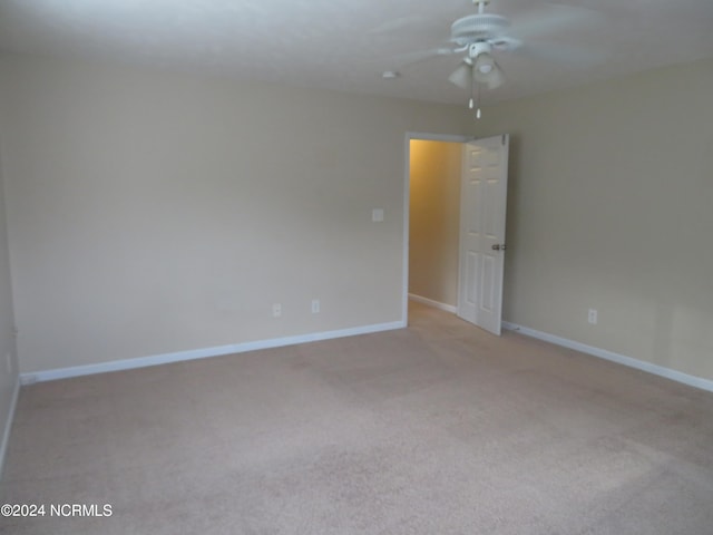 carpeted spare room featuring ceiling fan