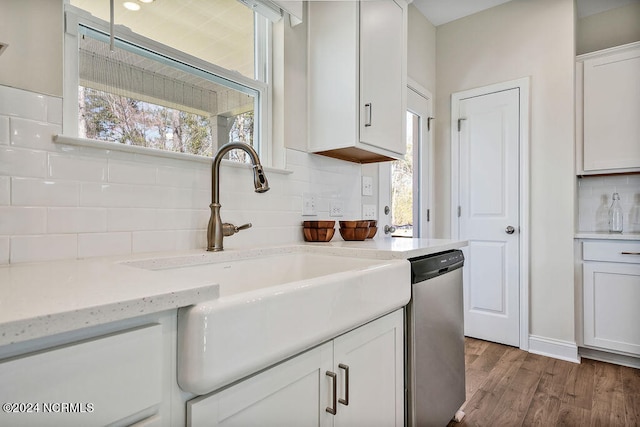 kitchen featuring light stone countertops, dishwasher, wood-type flooring, sink, and white cabinets